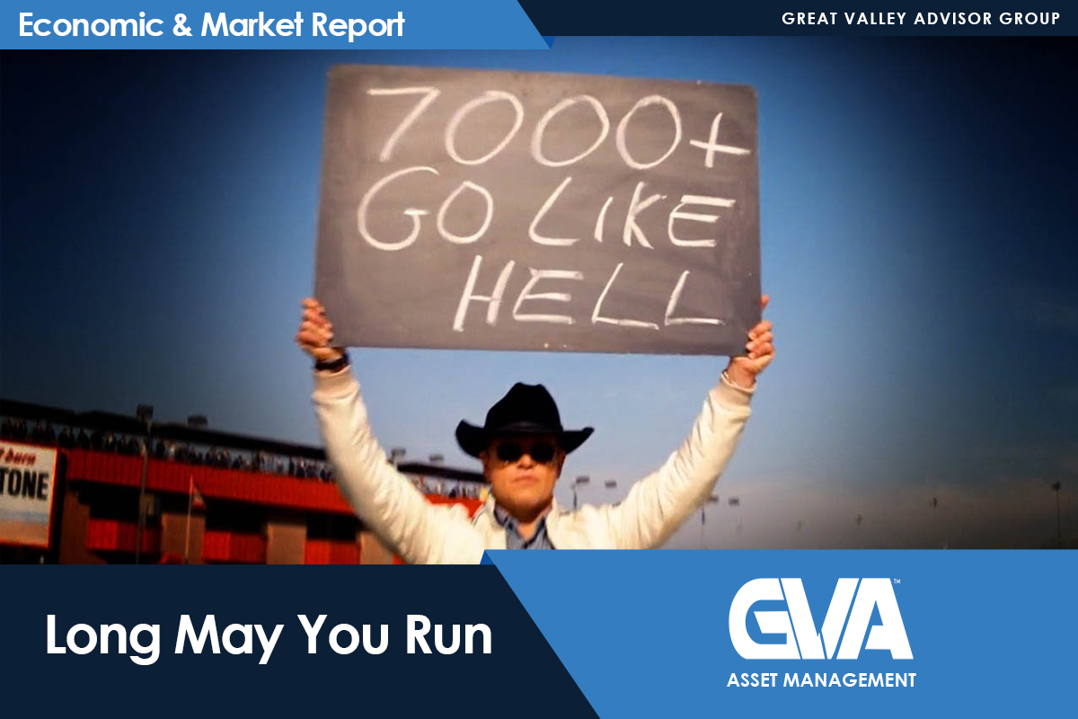 Person in a hat and sunglasses holds a chalkboard sign that reads '7000+ GO LIKE HELL' at a stadium, with 'Long May You Run' and GVA Asset Management branding overlayed.