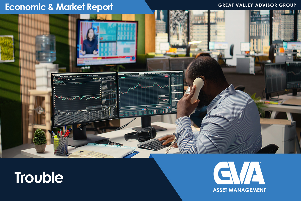 Man in a striped shirt on a phone at a trading desk with multiple monitors showing market charts, in a busy office setting with a banner reading 'Economic & Market Report'.